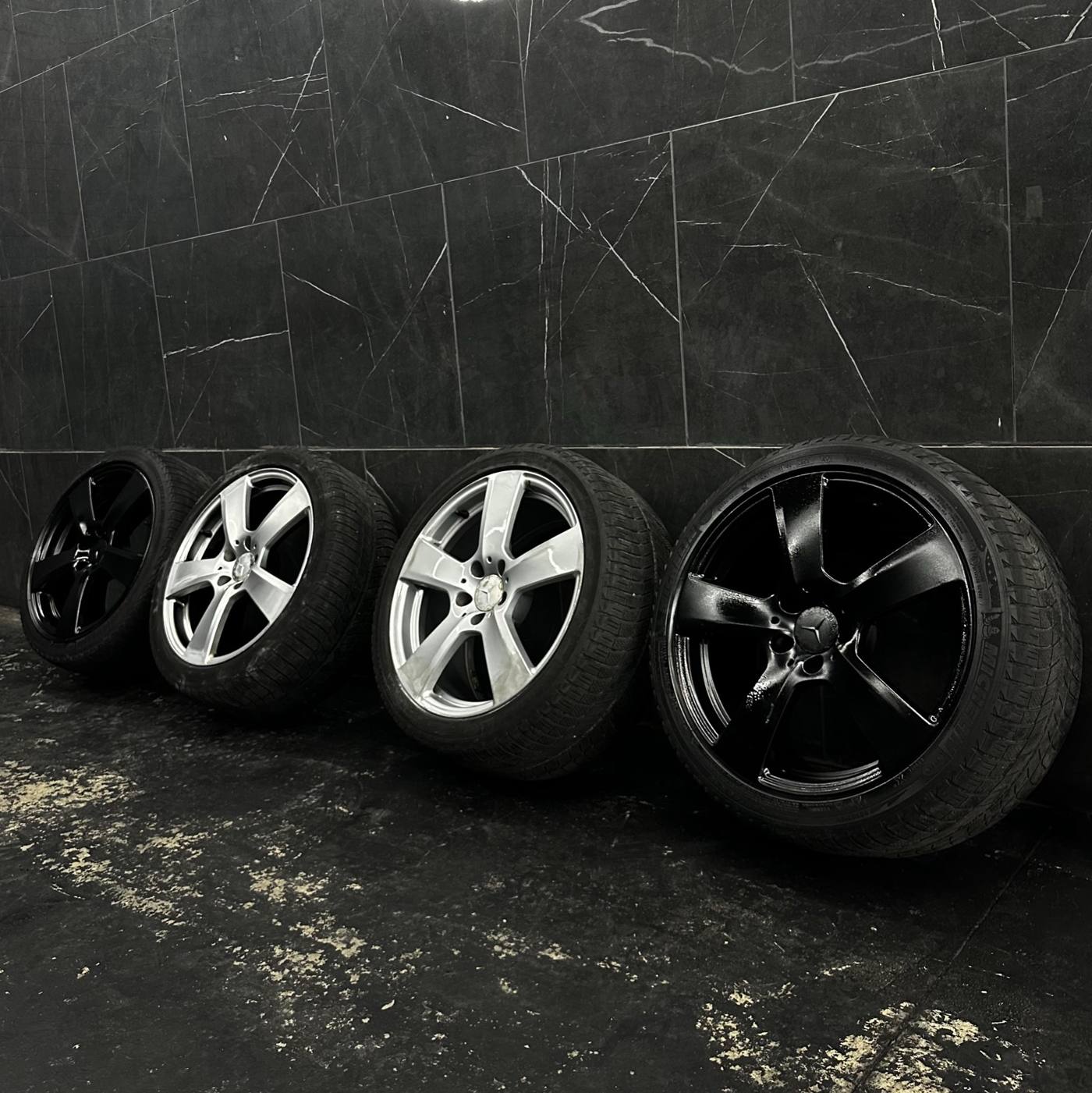 Four refinished wheels lined against a marble wall